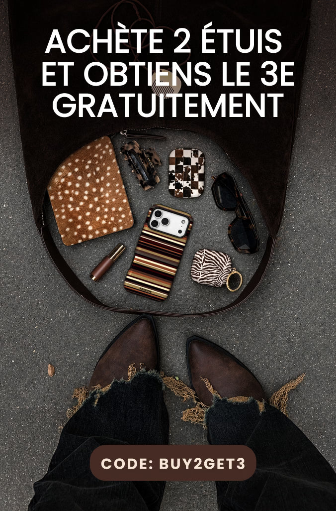 Promotional graphic showing an open dark brown leather suitcase on gray pavement with various accessories inside, including a patterned clutch, sunglasses, a striped phone case, and a small wallet. Large white French text reads 'ACHÈTE 2 ÉTUIS ET OBTIENS LE 3E GRATUITEMENT' with a brown label at the bottom reading 'CODE: BUY2GET3'.